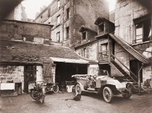 Eugene Prints: Automobile and two motorcycles in courtyard on Rue de Valence