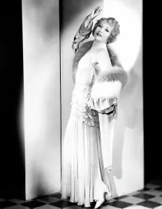 Glamorous Prints: Betty Compson, modeling a pale green evening gown and velvet wrap, trimmed with fur, 1935