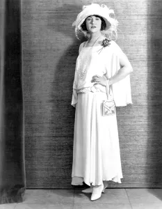 Feathered Hat Prints: Betty Compson, modeling a white crepe travelling frock, 1923