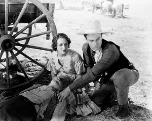 Squatting Prints: THE BIG STAMPEDE, kneeling, from left, Mae Madison, John Wayne, 1932