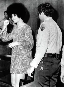 Angela Prints: Black militant Angela Davis gives clenched fist salute as she appears briefly