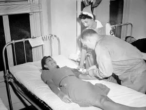 Red Cross Prints: Blood Transfusion. A volunteer blood donor giving her blood at a Red Cross donor center