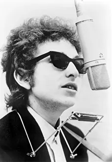 Dylan Prints: Bob Dylan (b. 1941) with harmonica, standing behind overhead microphone. 1967
