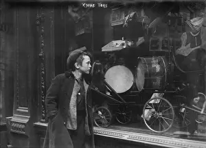 Holiday Prints: Boy looking through window at Christmas toys, titled: Xmas Toys, circa 1900s