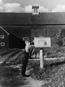 Boy reaching into the mailbox on the McNally farm in Kirby Vermont. September 1937. (BSLOC_2010_18_84)