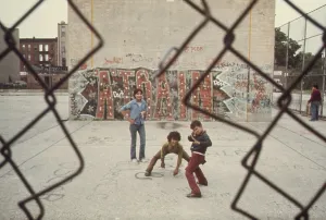 Inner City Prints: Three boys at play in Brooklyn's Lynch Park with Graffiti art spelling out A-Train