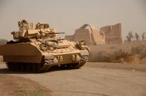 Iraq Prints: US Bradley Fighting Vehicle passes by the ruins of the palace of historic Ctesiphon one of the great cities of ancient