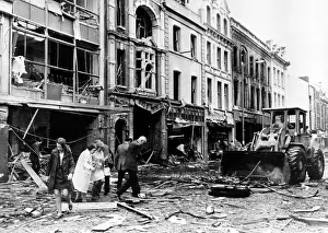 Debris Prints: A bulldozer clears away debris in a devestated shopping area following the explosion of a 250-pound bomb