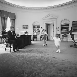 Fathers Prints: Caroline and John Jr. dance in the Oval Office as President Kennedy claps. 1962