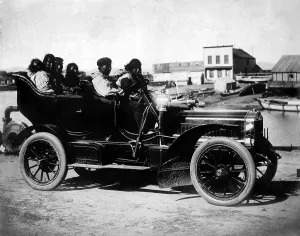 Truck Prints: Cars. Eskimos, five adults and one infant, sitting in an automobile, Oct 5, 1906