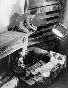 Lilyan Prints: Cecil Beaton (1904-1980), kneeling on mantle of fireplace to take photograph of Lilyan Tashman (1899-1934)