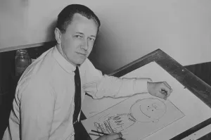 Cartoons Prints: Charles Schulz (1922-2000), seated at drawing table with drawing of Charlie Brown