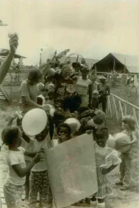 Communes Prints: Children from the Jonestown Pre-School in a parade carrying a poster