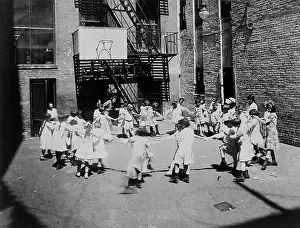 Charity Prints: Children play ring-around-a-rosy in a settlement house yard, 1918