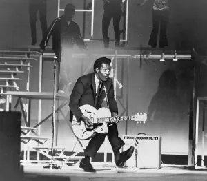 Dance Prints: Chuck Berry (b. 1926) on stage, playing guitar. 1965