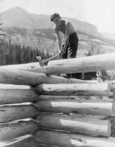 Axes Prints: Civilian Conservation Corp worker cutting a coped joint on log cabin at Granite Creek