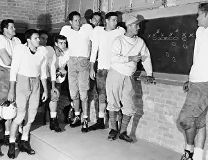 Teamwork Prints: Coach Blair Cherry diagrams plays for the Texas University football team