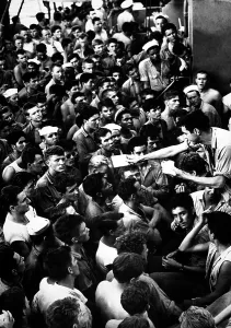 Mail Prints: Coast Guardsmen gather as mail call takes place aboard a troop transport