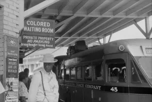 North Carolina Prints: Colored Waiting Room sign. African Americans stand under a Jim Crow sign at the bus station in Durham