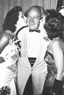 Pageants Prints: Conrad Hilton is kissed by Miss Universe Gladys Zender (left) and the runner up