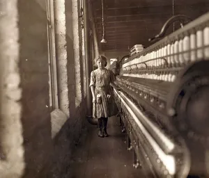 North Carolina Prints: Cotton Mill. An underage girl tends a cotton spinner