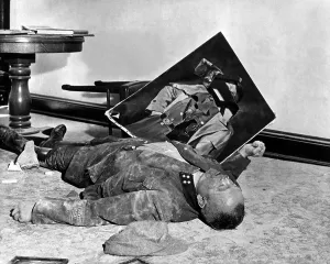 Militia Prints: A dead Volksstrum general lies on the floor of city hall with a torn portrait of Hitler