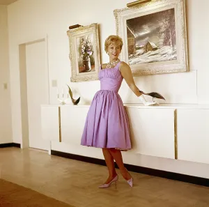 Dinah Prints: Dinah Shore at home, (paintings she created are on the wall behind her), circa 1960s
