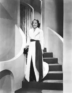 THE DIVORCE OF LADY X, Merle Oberon in white Russian Ermine coat by Paquin and black velvet evening gown designed by Rene Hubert, 1938