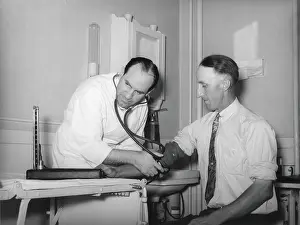 Patient Prints: Doctor at a medical cooperative taking blood pressure of a patient in Box Elder County