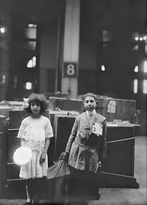 Luggage Prints: Two well dressed immigrant children tagged with ERIE labeled at Ellis Inland