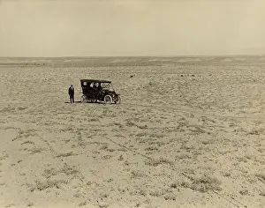 Convertible Prints: Early automobile parked in an expansive area of barren land in the Grand Valley