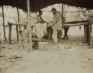 Science Prints: Edmund Heller (seated), Smithsonian naturalist, works with African men to clean a specimen