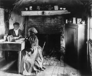 Wood Floor Prints: Elderly African American couple eating at the table by a fireplace