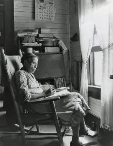 Curtains Prints: Elderly African American woman writing in a rocking chair