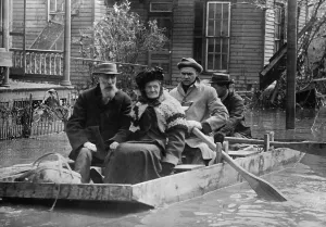 Workers Prints: An elderly couple is evacuated from their Dayton home in a small wood boat in March 1913