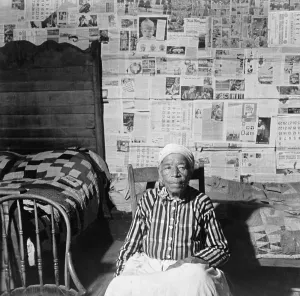 Newspapers Prints: Elderly former slave in her sitting in her news papered home in May 1941