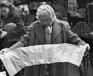 Gray Hair Prints: Elderly woman evaluating a corset at a pushcart market on Belmont Avenue