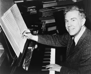 Symphony Prints: Elliott Carter (b. 1908), American composer seated at piano, editing sheet of music