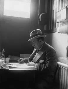Caruso Prints: Enrico Caruso (1873-1921) reading in a New York City restaurant. Ca. 1915