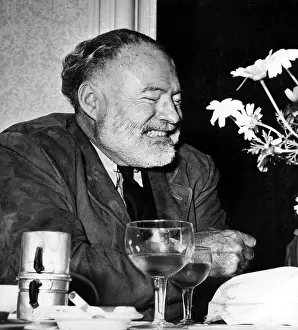 Author Prints: Ernest Hemingway drinks wine and coffee at a restaurant in Genoa