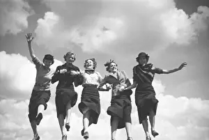 Sportswear Prints: Five fashion models holding hands and walking in a row with the sky as backdrop
