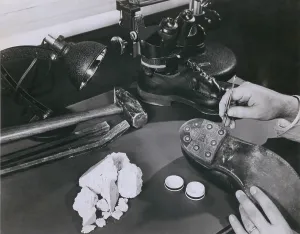 Criminal Prints: FBI forensic science. A technician removing safe insulation from the shoes of a burglary suspect at the FBI lab in 1954