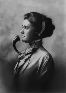 Headphones Prints: A female telephone operator wearing earphones and a mouth piece. Ca. 1911