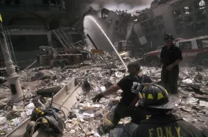 Skyscraper Prints: Fire fighters set up a hose amid smoking rubble following September 11th terrorist attack on World Trade Center