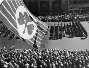 Patriotism Prints: Flag with shamrock flies above Fifth Avenue as Saint Patrick's Day Parade passes below