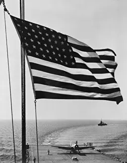 Sailors Prints: Flag of the United States snaps in the breeze over the USS Santee