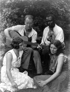 Negro Prints: Folk Music. Four musicians including a man playing a guitar