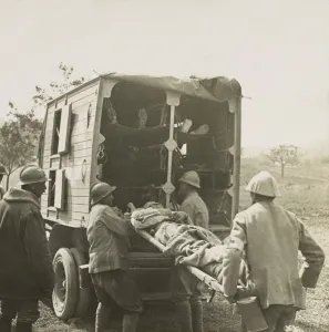 Patients Prints: French soldiers load stretchers with wounded into motor ambulance for evacuation in World War 1