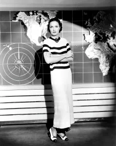 Patrick Prints: Gail Patrick, modeling a cruise ensemble of brown and white crepe