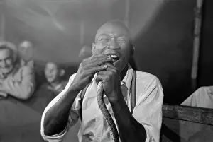 Sideshow Prints: Geek biting the head of a snake at a sideshow, Louisiana State Fair, 1938